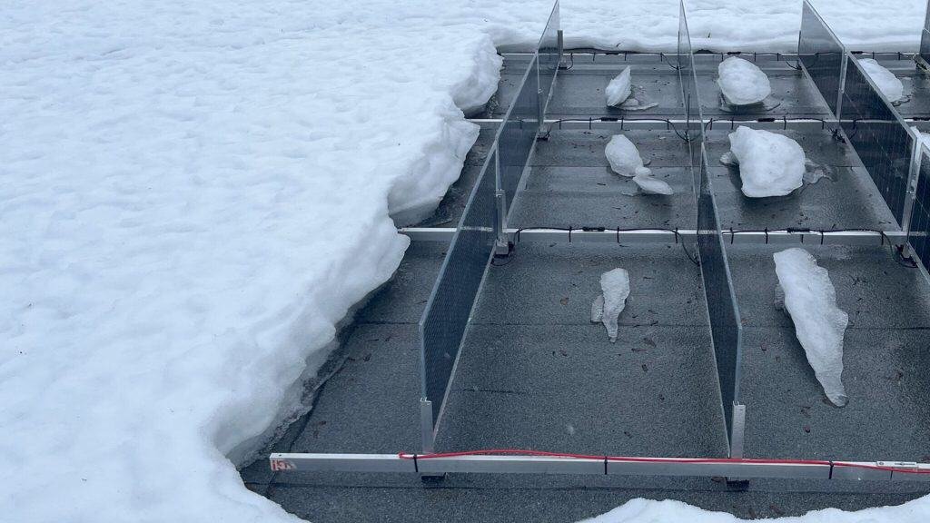 تظل الألواح الشمسية المثبتة عموديًا خالية من الثلوج، مما يوضح إعدادًا فعالًا للأداء في الشتاء