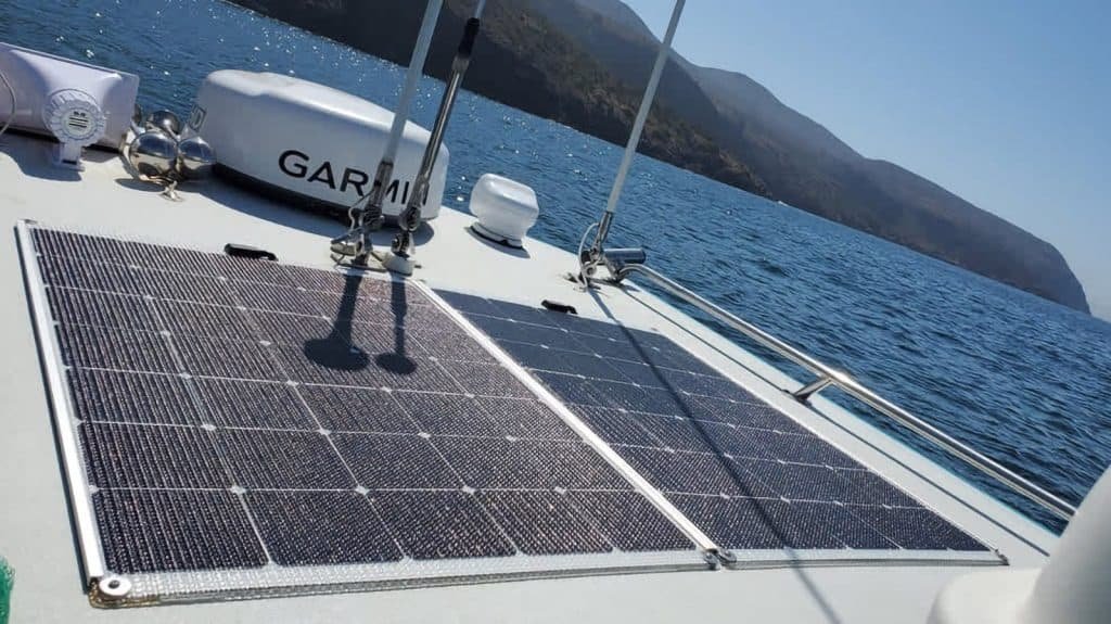 Semi-rigid solar panels are integrated onto the deck of a boat, showcasing a custom marine solar installation