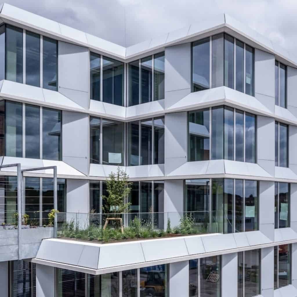 Modern building facade featuring custom white lightweight solar panels integrated as part of the architecture for aesthetic and functional BIPV use